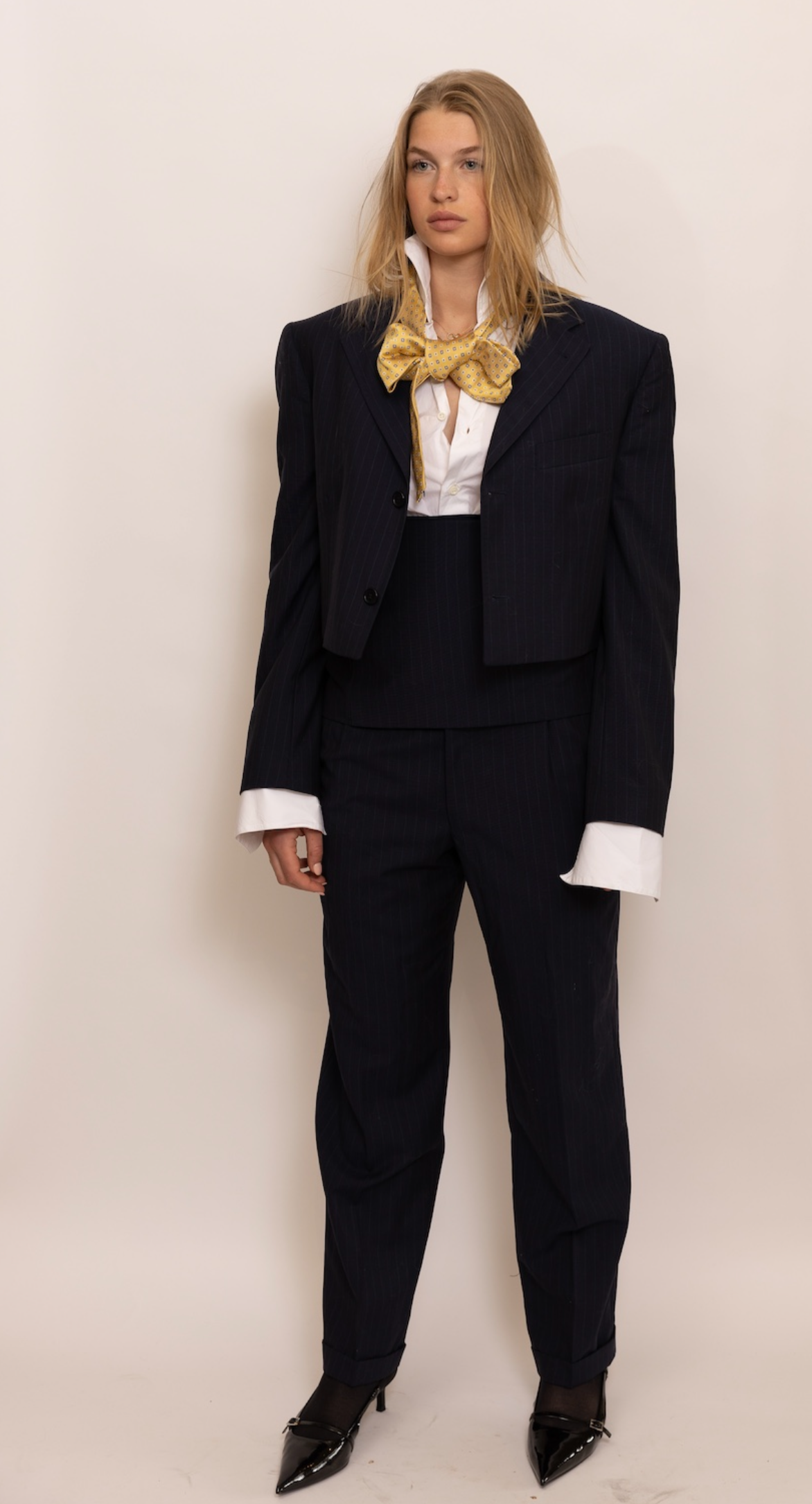 Cropped navy pinstripe trousers.